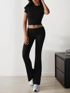 Close-up of women's black short-sleeve crop top and high-waisted flared pants set