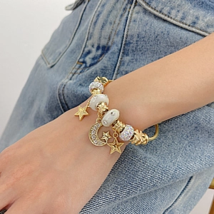 Detail shot of a star and moon charm bracelet with wire twist band on a wrist
