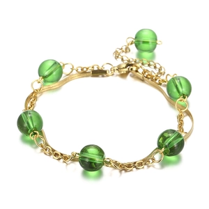 Gold double-layered stainless steel bracelet with green pearls on white background