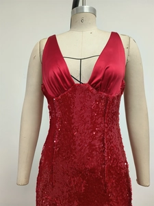 Detail of burgundy sequin evening dress with satin deep V-neckline on mannequin