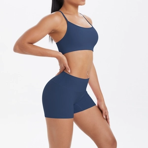 Vue latérale d'un ensemble de sport bleu foncé avec brassière à fines bretelles et short taille haute