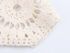 Gros plan détaillé montrant le motif de tricot au crochet sur une jupe en coton blanc cassé