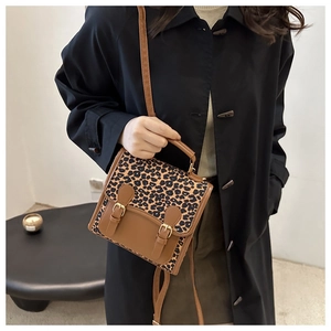 Detail view of the vintage leopard print handbag with golden buckles and shoulder strap