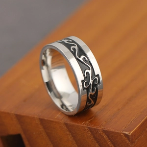 Retro stainless steel dragon pattern ring with black inlay on a natural wood surface