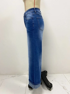 Dettaglio di jeans in denim a vita alta con tasca laterale e orlo con risvolto