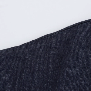 Macro del tessuto denim blu scuro che mostra la trama a saia dettagliata su un abito vintage