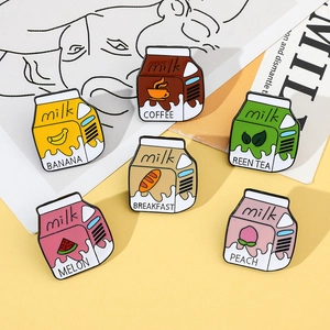 Detailed view of six cute enamel pins shaped like assorted fruit milk cartons on a yellow base
