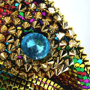 Detail of colorful sequins, gold studs and blue gemstone on a disco captain hat