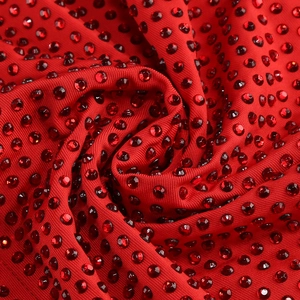 Macro shot of sparkling red rhinestones on premium stretch knit fabric for evening gown