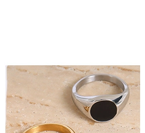 Macro shot of silver signet ring with black enamel inlay and gold band on stone