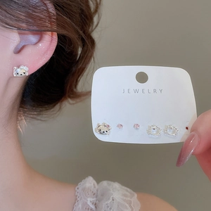 Close-up of cat-shaped silver earrings and pink zircon studs in a six-piece jewelry set