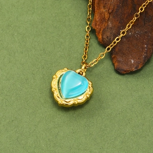 Détail du collier avec pendentif cœur en opale, bordure dorée vintage et chaîne