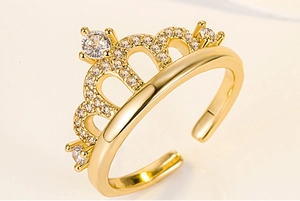 Close-up of a gold-plated crown ring featuring sparkling white cubic zirconia stones