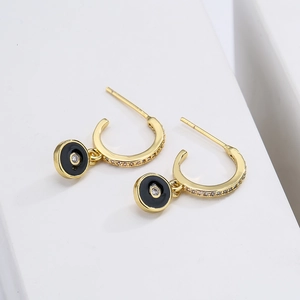 18K gold-plated copper hoop earrings with black zircon eye pendants on white pedestal