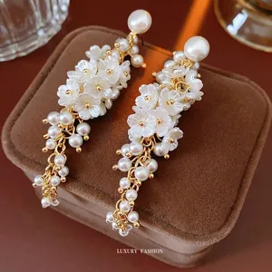 Elegant floral pearl tassel drop earrings in gold plating and white resin petals