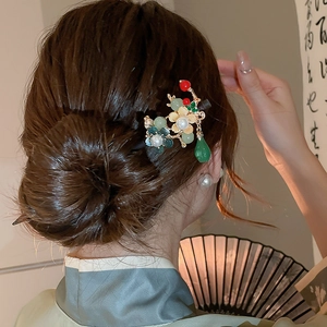 Detail view of a vintage Chinese butterfly hair pin with jade flowers and pearl tassels