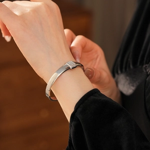 Gros plan d'un bracelet en acier titane argenté avec incrustation de strass sur le poignet