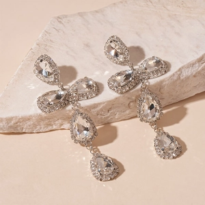 Macro detail of luxury silver drop earrings with faceted crystals and elegant tassels
