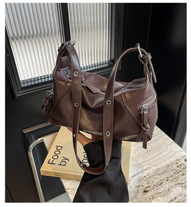Close-up of dark brown PU leather tote with silver metal grommets and brand logo
