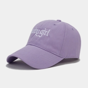 Detail of white Babygirl gothic embroidery on purple cotton twill baseball cap