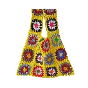 Close-up of handmade crochet tote bag featuring colorful granny square floral patterns