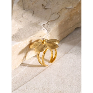 Macro view of gold flower ring featuring brushed texture petals and a sparkling zircon stone
