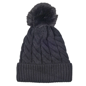 Close-up of black cable knit beanie texture with a matching faux fur pom-pom detail