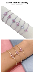 Detail of pink zircon bracelet featuring heart and flower charms on a tennis chain