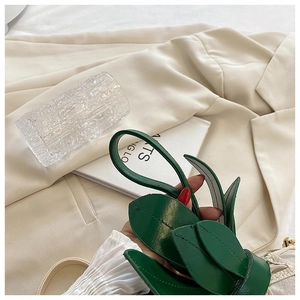 Detail of green leaf-shaped leather bag handle with precise tonal stitching work