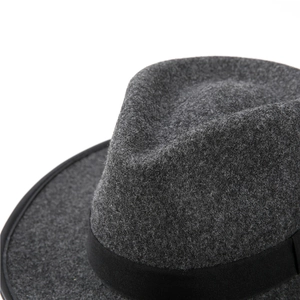 Close-up of the dark gray wool felt texture and black decorative ribbon on a jazz hat