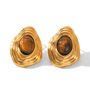 Close-up of vintage gold earrings with tiger eye stone and irregular textured metal
