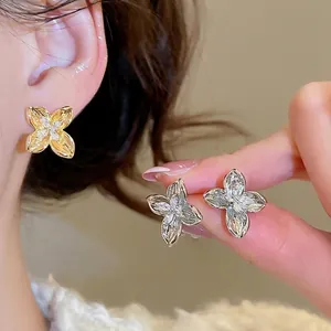 Elegant floral stud earrings with sparkling zircon crystals in gold and silver finishes