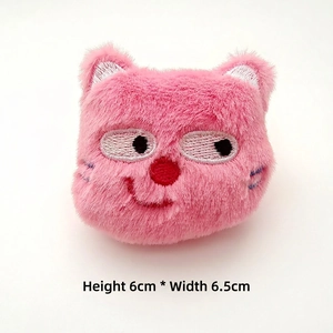 Close-up of pink plush cat badge with embroidery, measures 6cm height and 6.5cm width
