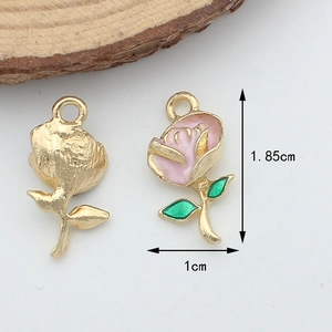 Macro view showing both front pink floral enamel and gold metal back of a small rose pendant