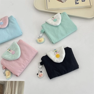 Vue de dessus de quatre mini-portemonnaies colorés avec pendentifs et rabats en peluche