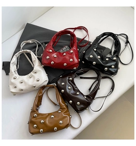 Detail showing five colors of studded underarm bags with metallic spheres on PU leather