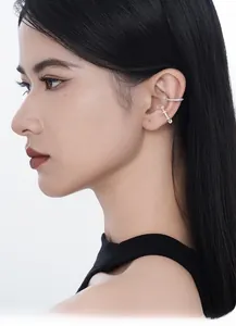 Macro detail of S925 silver CZ paved and gold twisted ear cuff set on model ear