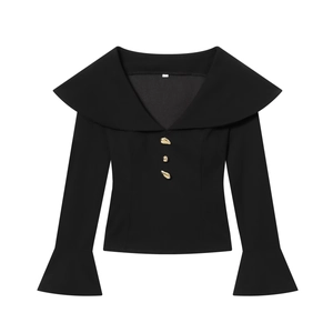 Close-up of black blouse with large lapel and three irregular golden decorative buttons