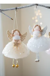 Detail of Christmas angel ornaments with sequin mesh skirts and bells on a branch