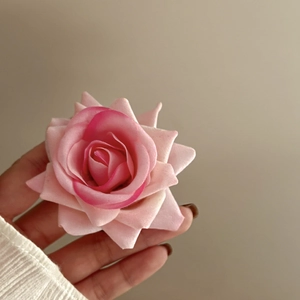 Macro detail of the layered pink fabric rose petals with realistic gradient texture