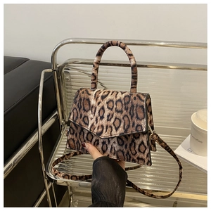Detailed view of the leopard print handbag texture with leather handle and metal hardware