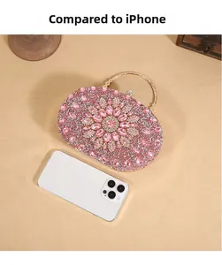 Pink rhinestone evening clutch bag with flower pattern next to iPhone for size scale