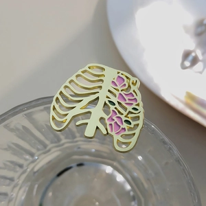 Artistic skeleton ribcage brooch with colorful floral enamel detail on glass edge
