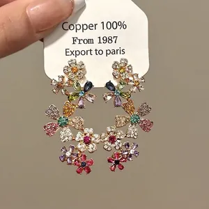 Elegant drop earrings featuring colorful floral crystals on a polished brass base