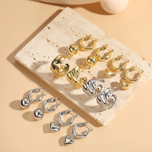 Orecchini a cuore e sfera lucidi in finitura oro e argento dallo stile minimalista