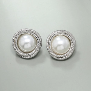 Detailed view of silver twist frame stud earrings with central baroque pearl inlay