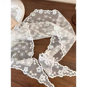 Close-up of white lace floral embroidery headband on a vintage wooden background