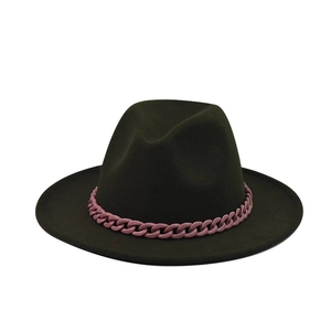 Détail d'un chapeau fedora en laine vert foncé avec une grosse chaîne en plastique rose vif