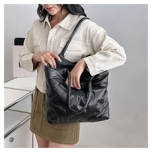 Detail der schwarzen gesteppten Tote-Bag aus gepolstertem Nylon mit Tragegriffen oben