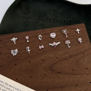 Pink heart and star zircon earrings collection in silver finish on wooden board